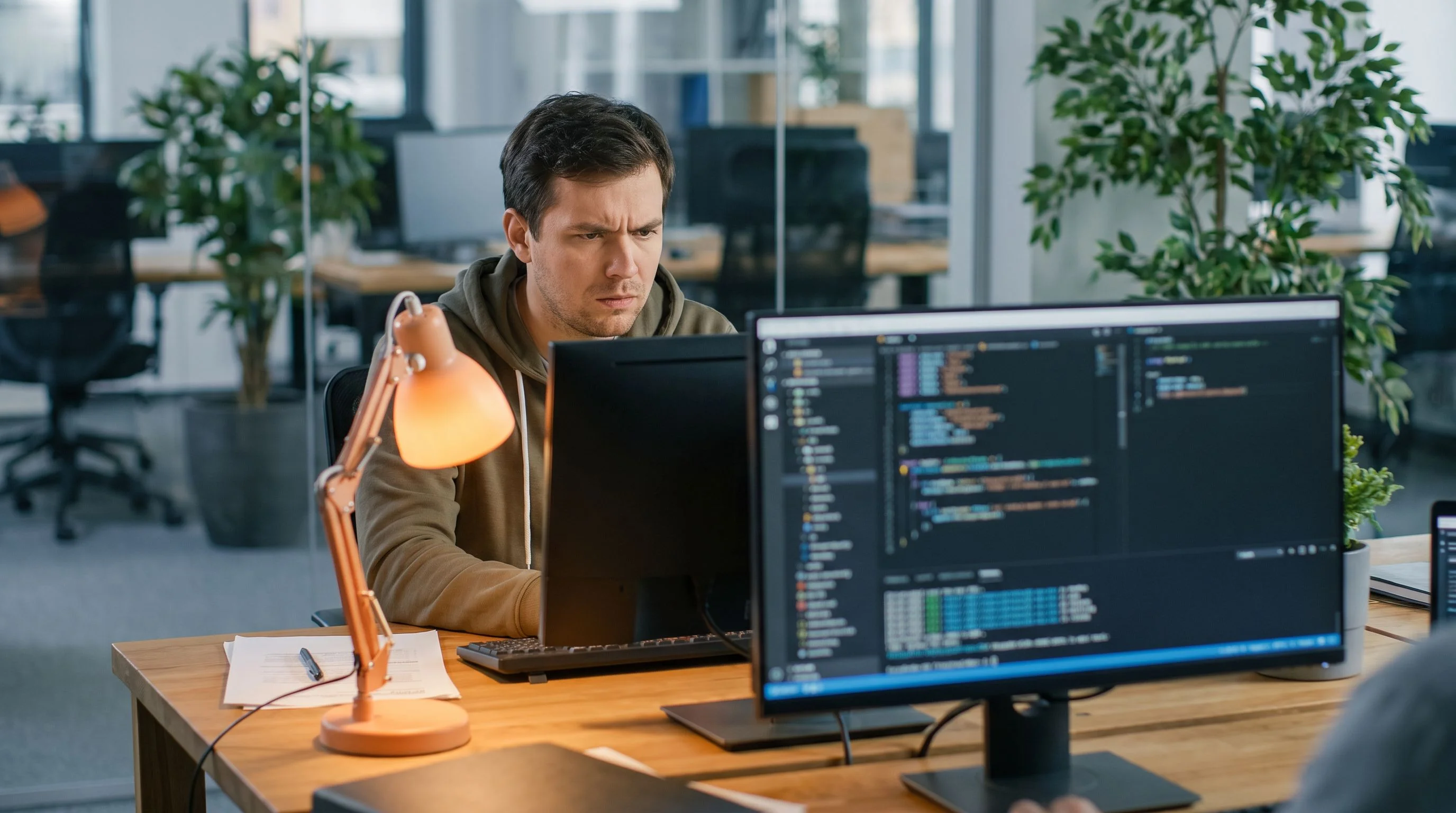 Developer working through an Angular technical screening assessment on dual monitors