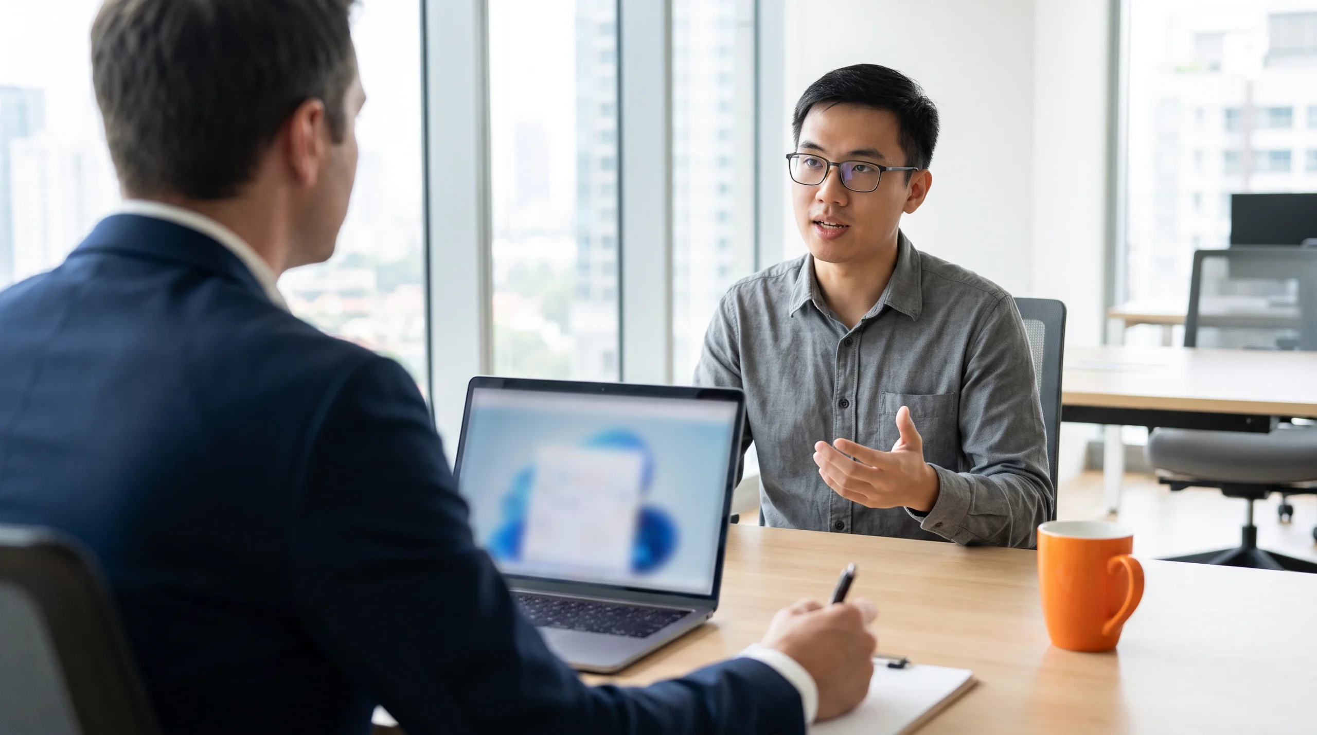 Hiring manager conducting a technical interview with an agentic AI engineer candidate in a modern office