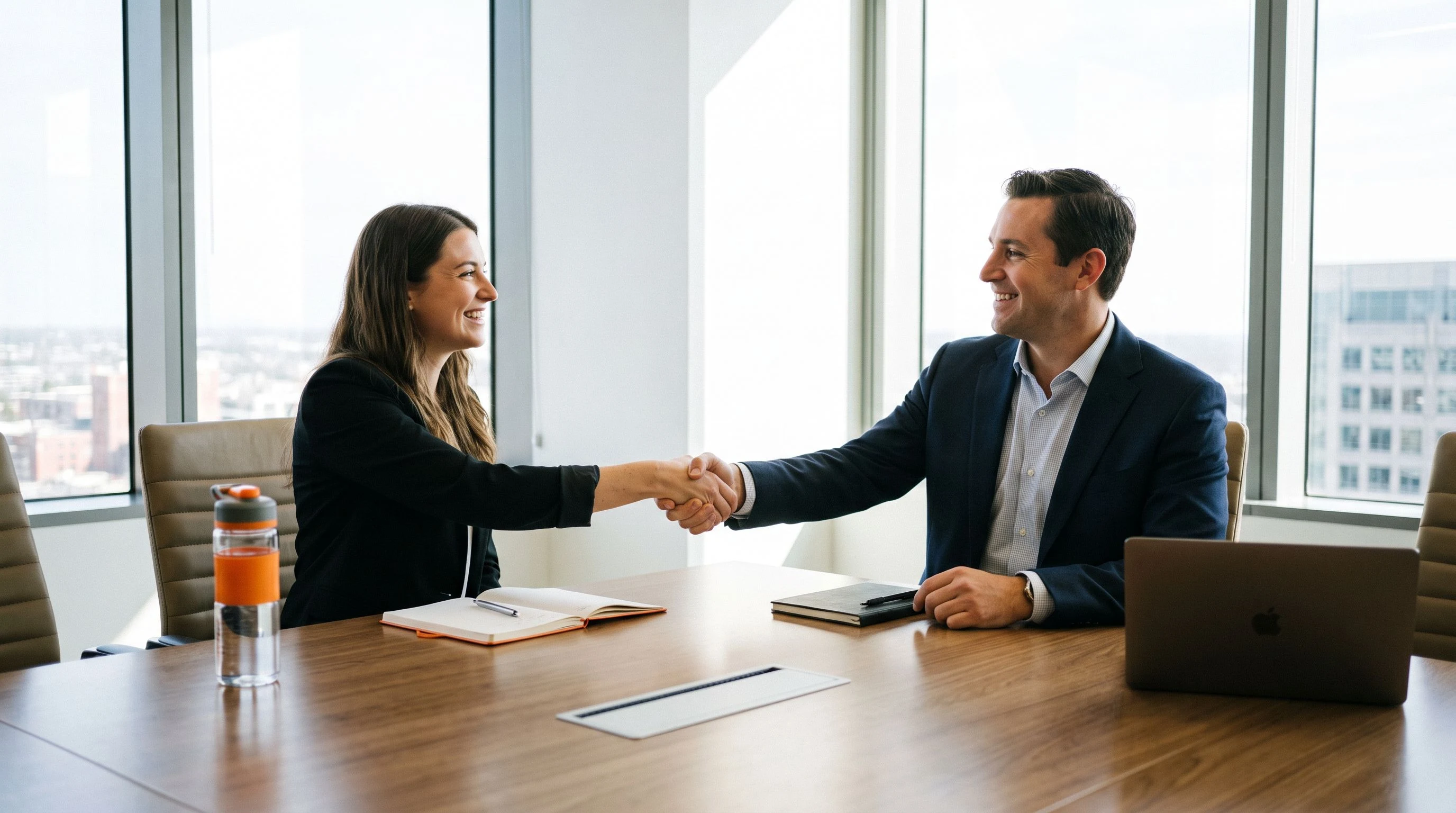 Hiring manager reviewing and preparing a compensation offer letter for a nearshore AI engineer at a desk with a laptop and printed salary data