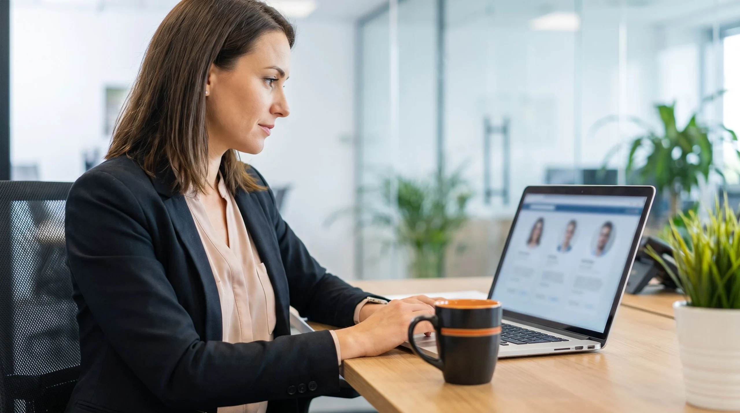 Hiring manager reviewing offshore customer service representative candidates on laptop at modern desk