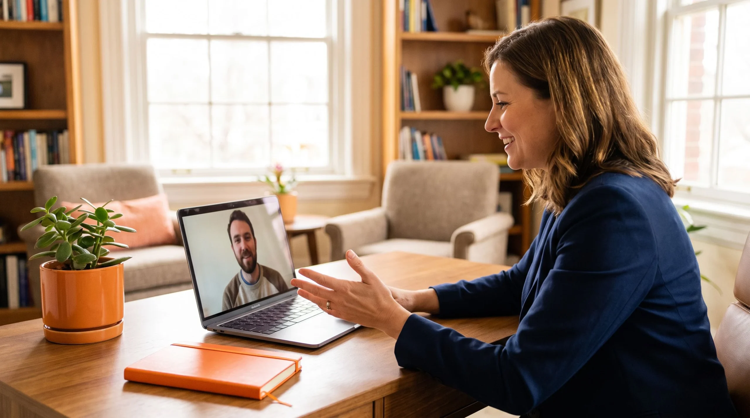 US manager on video call onboarding offshore CSR team member, warm office setting with orange accent