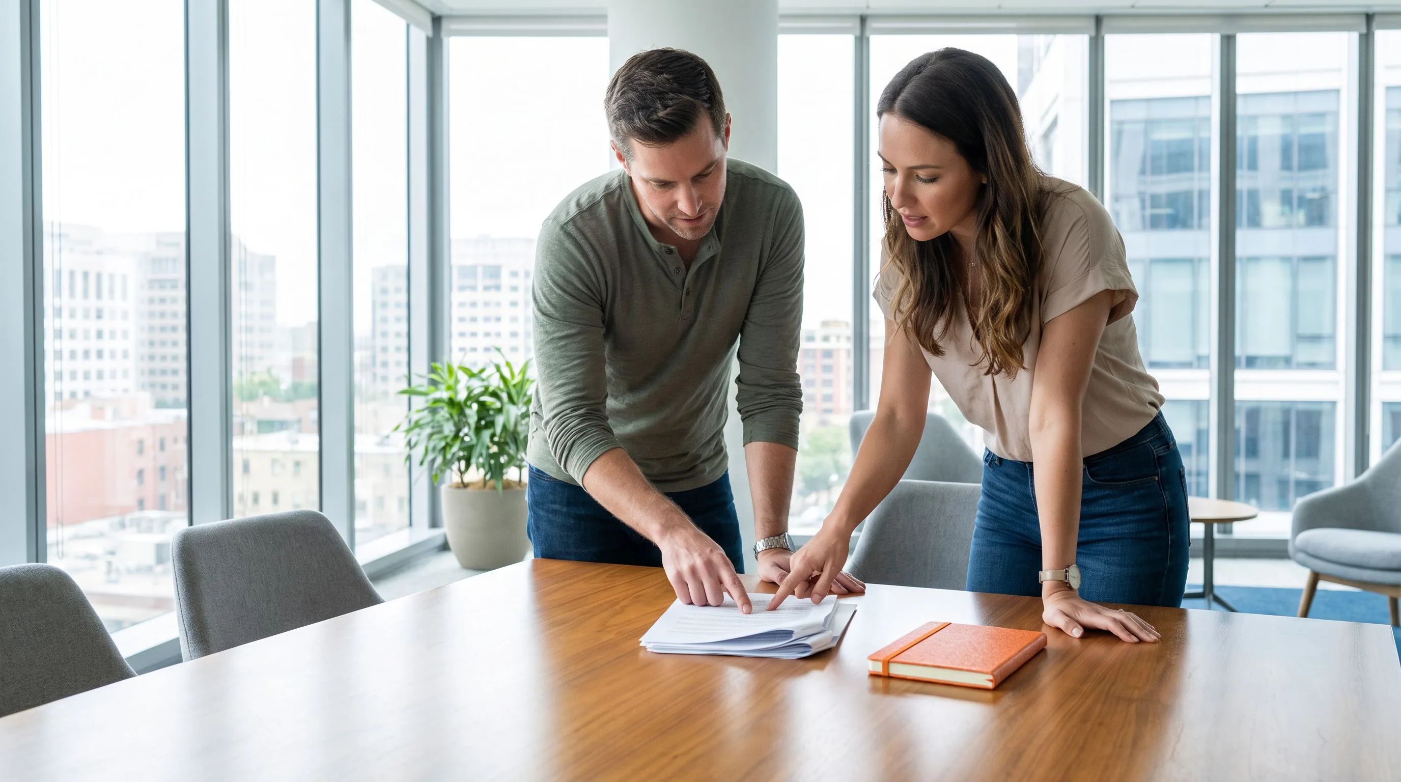 Interview panel of two professionals reviewing customer service candidate notes in a modern conference room