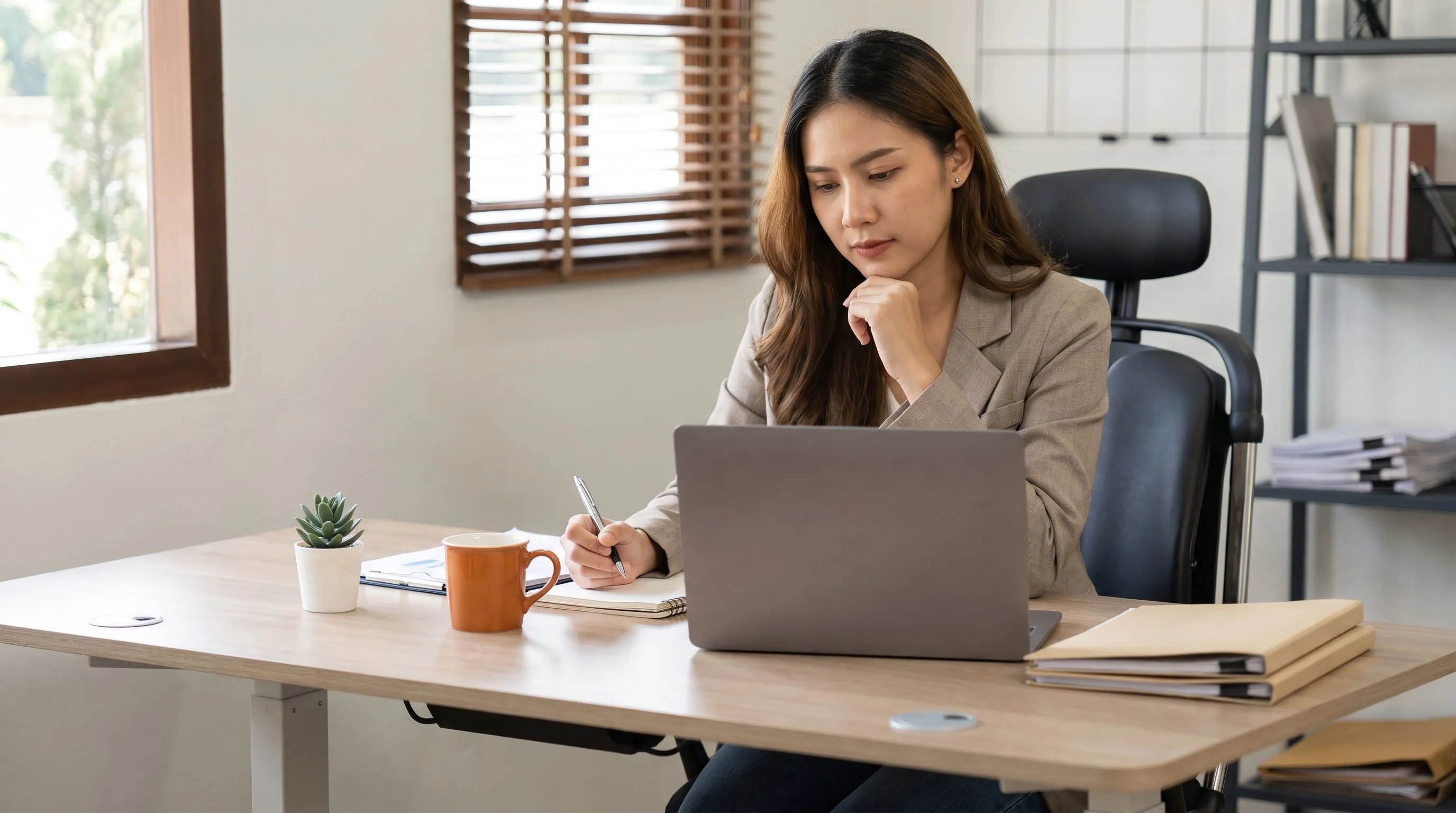 Hiring manager reviewing offshore customer support representative candidates on a laptop at a modern desk