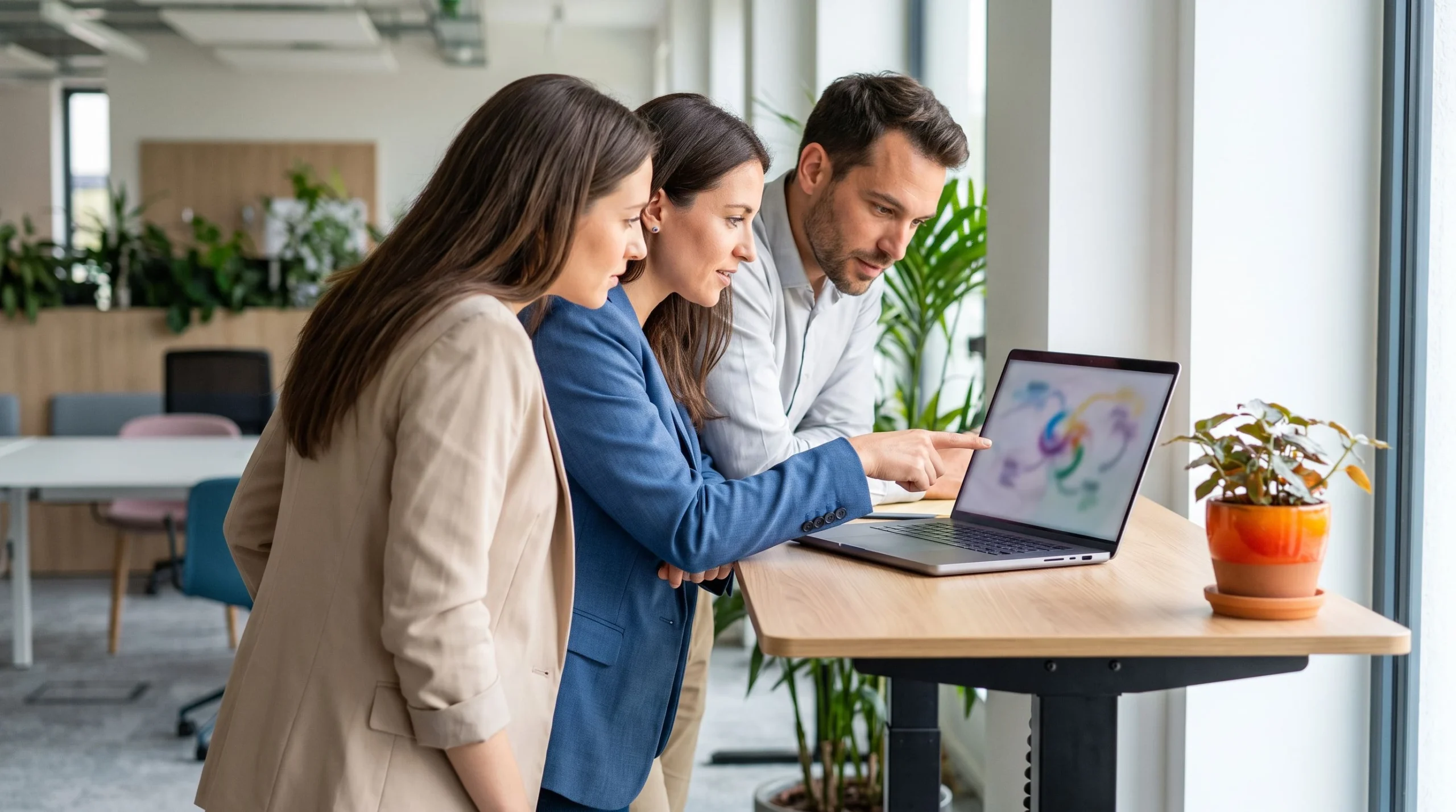 Small team reviewing a TOGAF architecture roadmap on a laptop around a table, over the shoulder angle, warm orange accent on a notebook