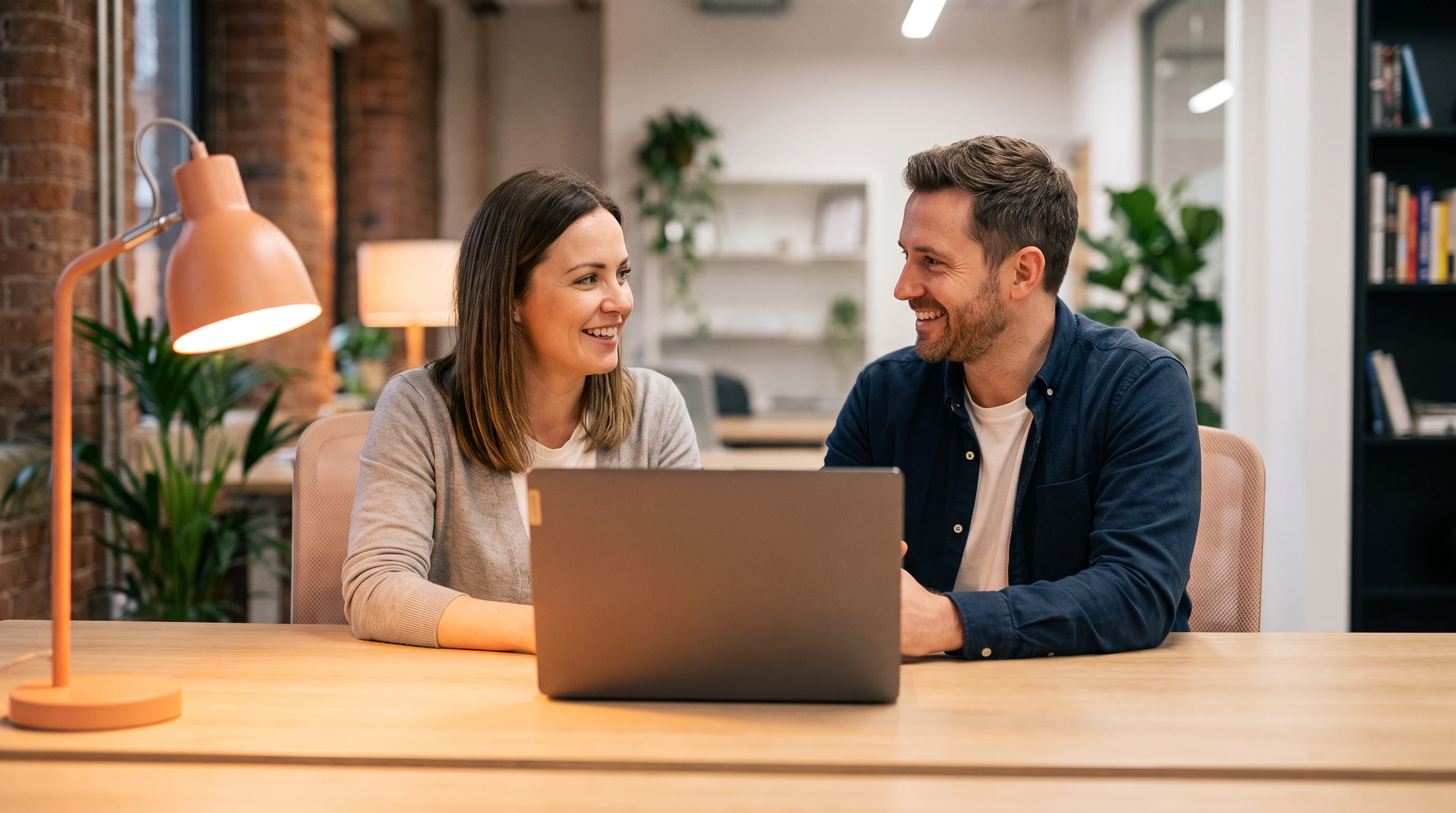 Hiring manager and candidate reviewing a Shopify developer job description together at a laptop