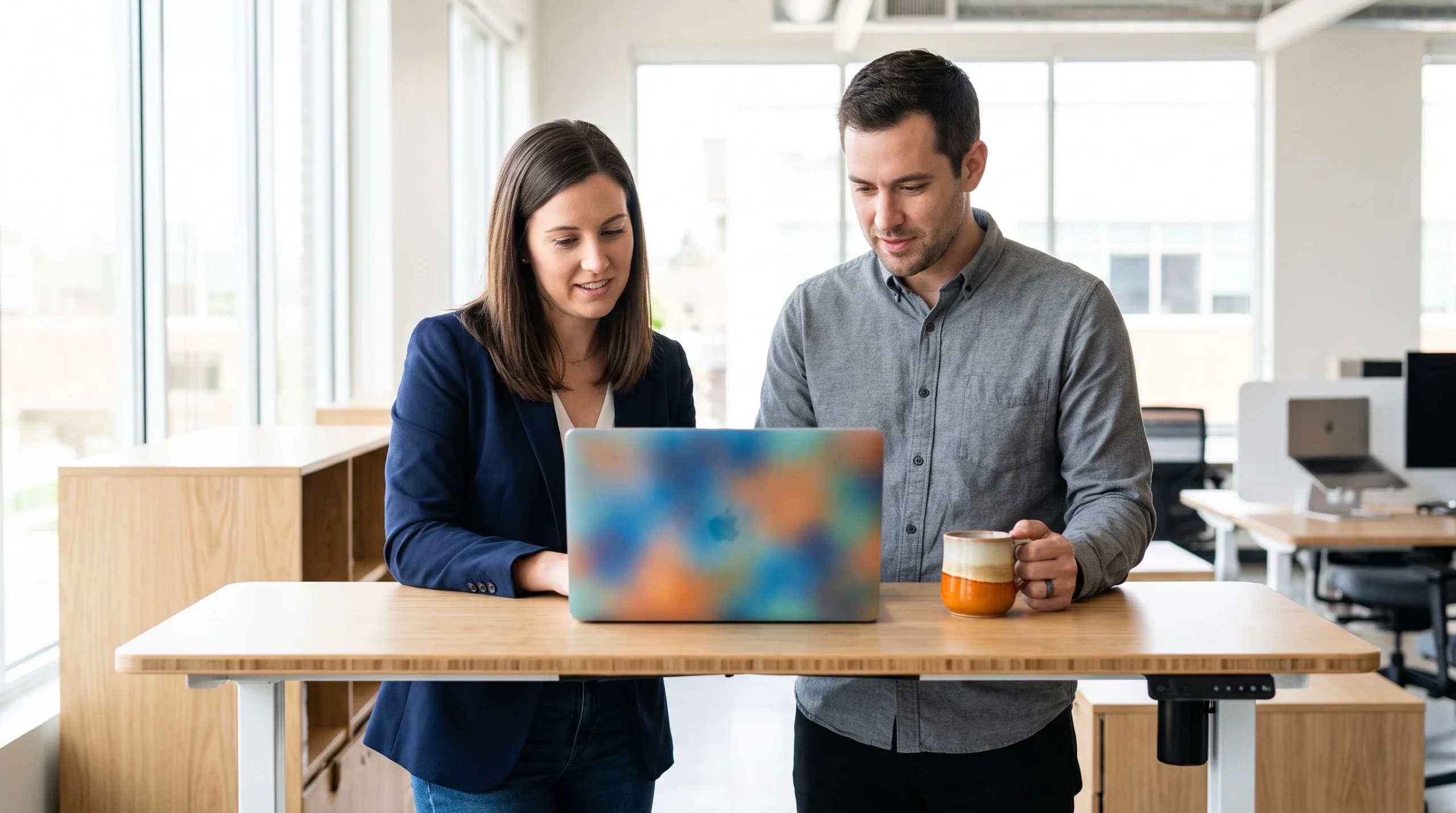 Two colleagues comparing 24/7 outsourced customer support pricing on a cost dashboard