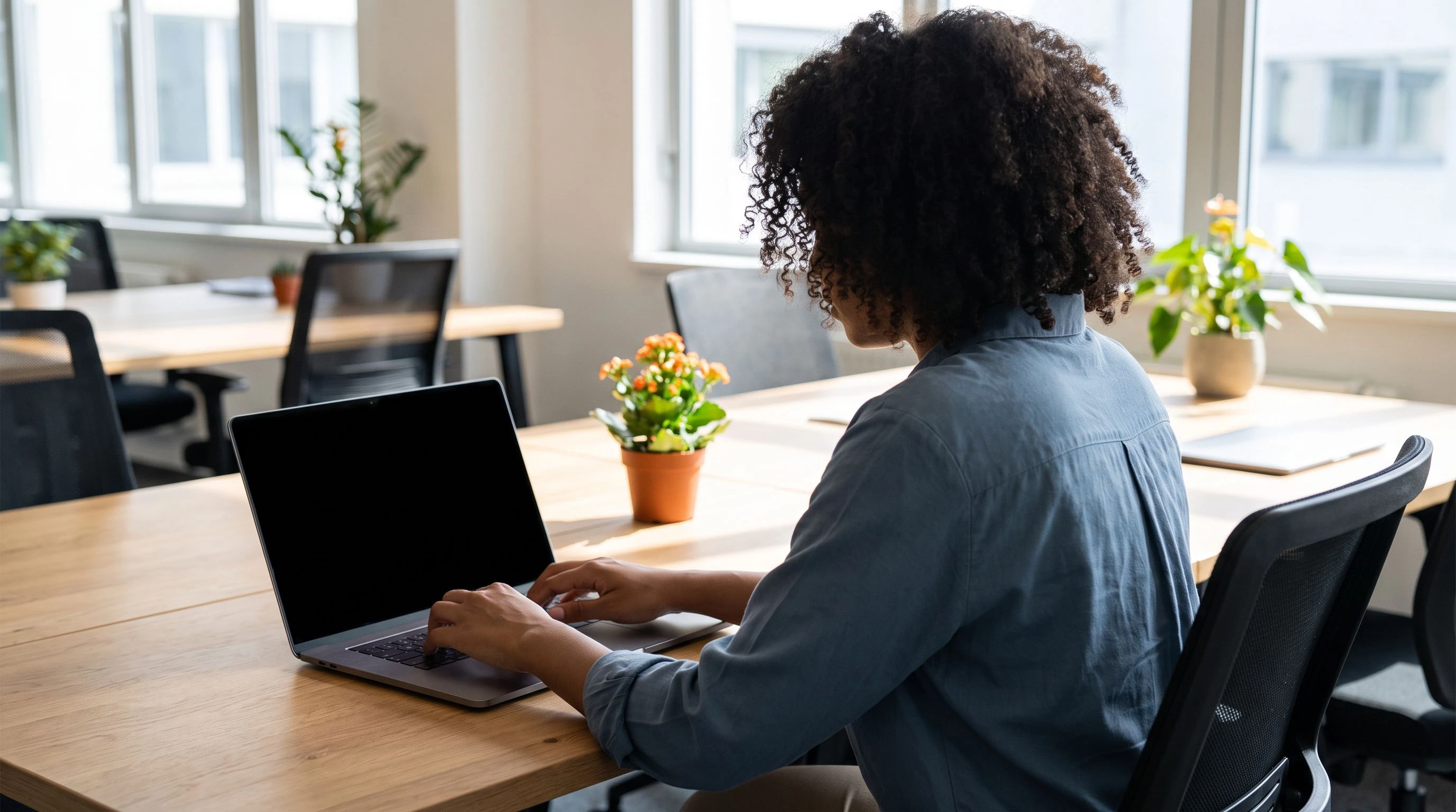 Offshore data processing professional working at a laptop for a US client