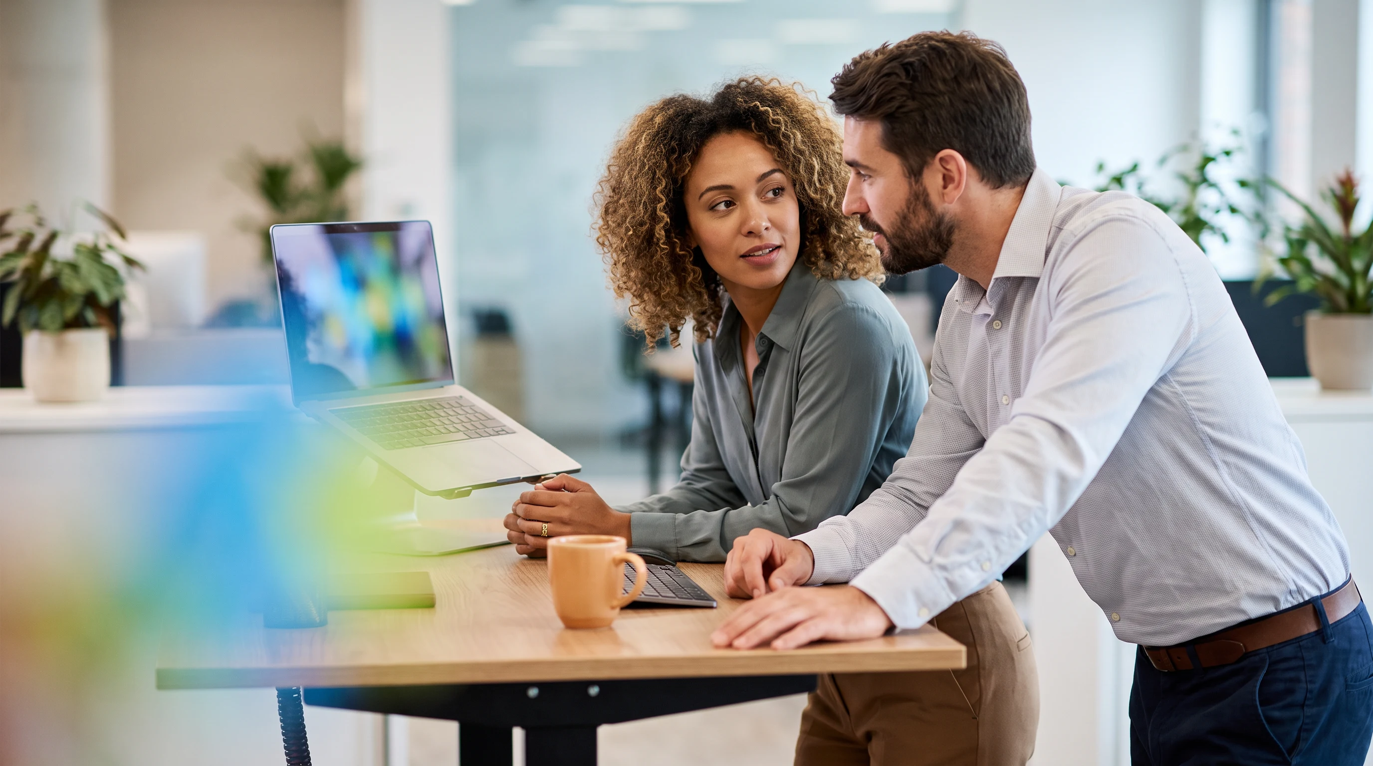 Two outsourced customer support teammates reviewing 2026 workforce trends together on a laptop