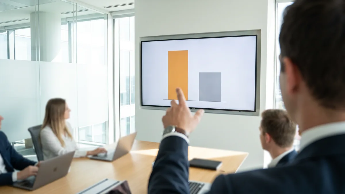 Bar chart style comparison image illustrating higher in-house help desk cost versus lower outsourced help desk cost