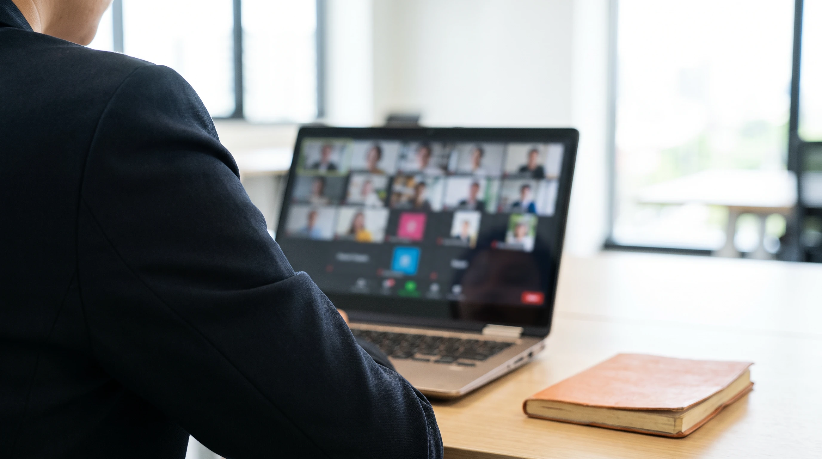 Hiring manager reviewing a blurred video call grid on a laptop screen