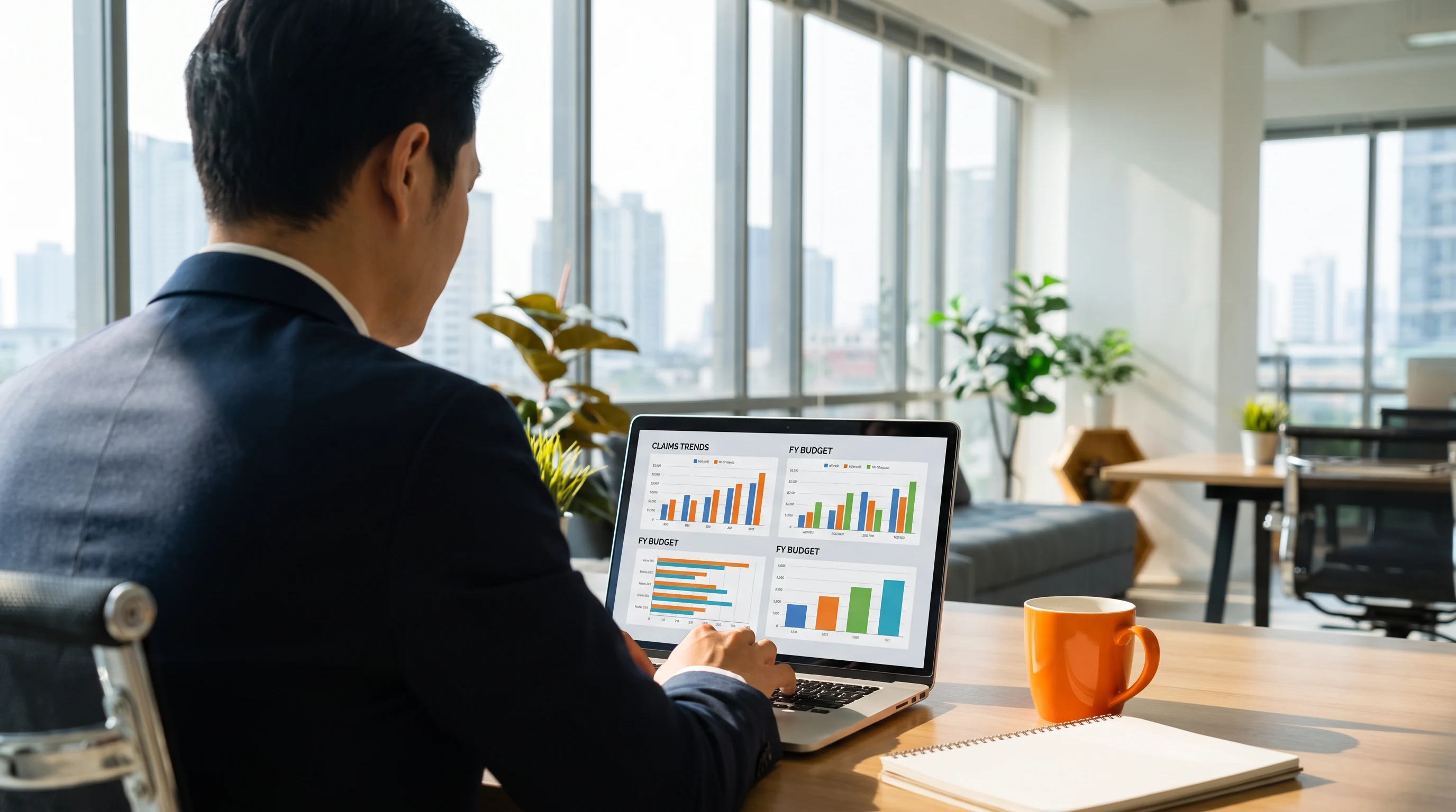 Business professional reviewing insurance claims cost data and budget charts on a laptop