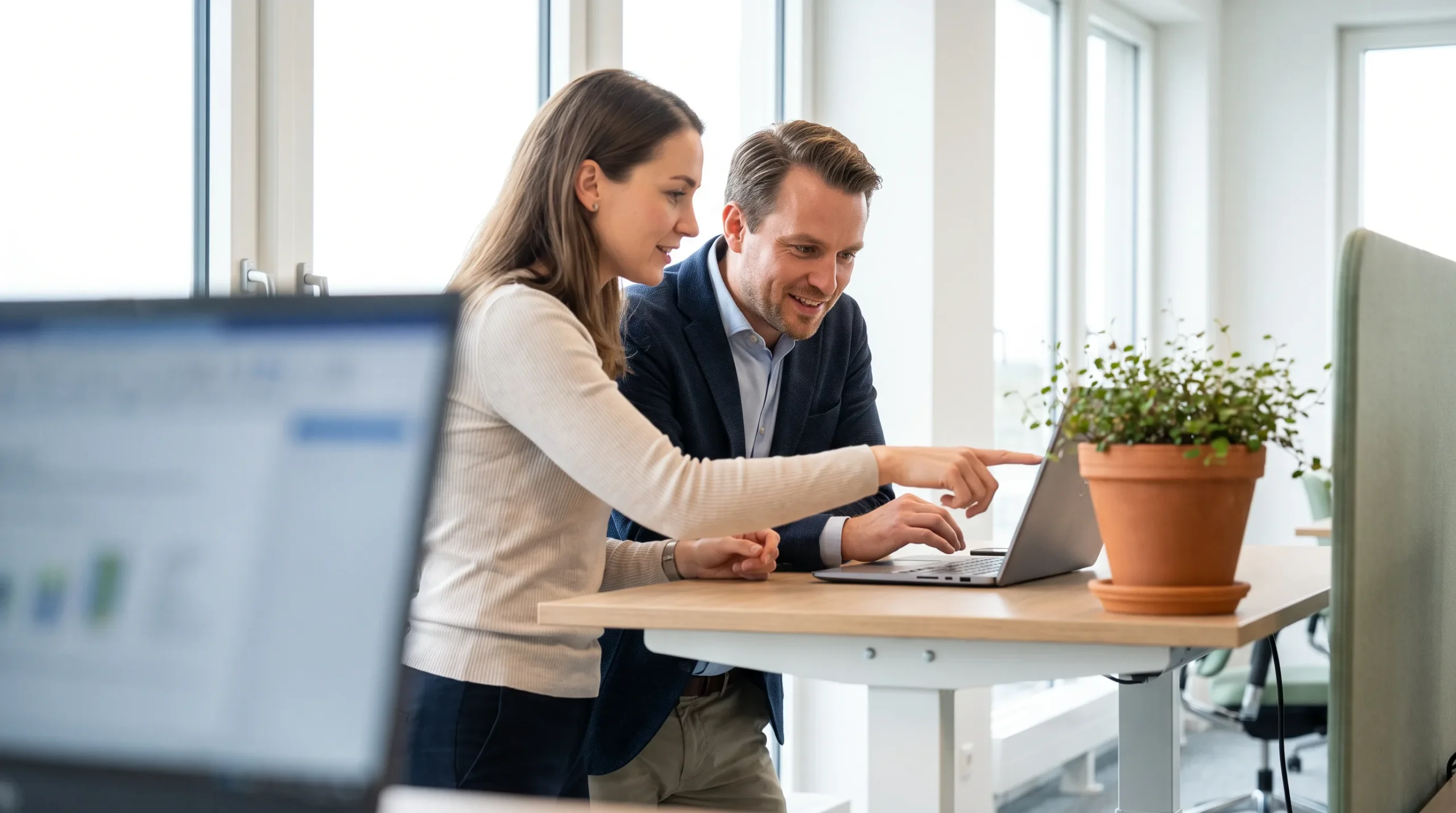 Two colleagues reviewing AI-assisted prospecting data together on a laptop