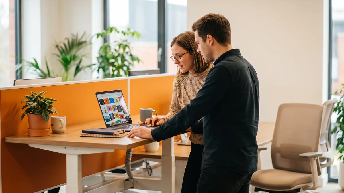 outsourced social media manager and brand marketer reviewing content calendar over the shoulder